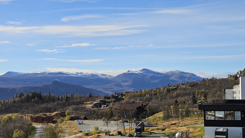 Utsiktsbilde mot fjellene i Jotunheimen. Blå fjell i det fjerne, blå himmel