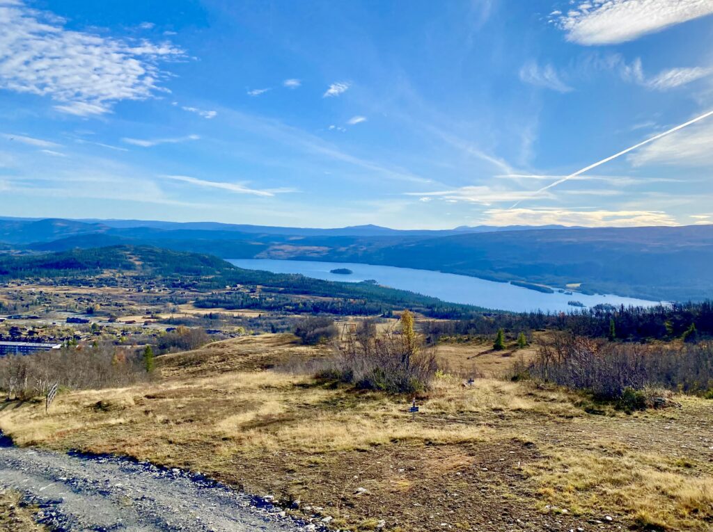 Naturbilde av utsikt fra skiheisen på Beitostølen. Fjell og innsjø i det fjerne. Høstfarger.